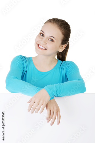 Photo: Portrait young happy woman with blank board Portrait young happy woman with blank board