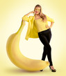 Photo: Woman standing next to a large banana Woman standing next to a large banana