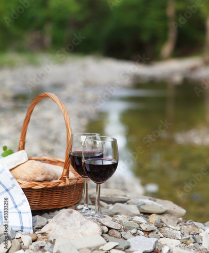 Photo: Red wine, cheese and bread served at a picnic Red wine, cheese and bread served at a picnic