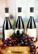 Photo: Composition of wine bottles, glass and grape,on wooden barrel, Composition of wine bottles, glass and grape,on wooden barrel,