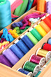 Colorful threads for needlework in wooden box close up
