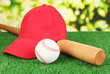 Photo: Red peaked cap on grass on natural background Red peaked cap on grass on natural background