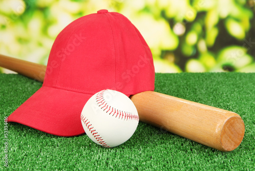 Photo: Red peaked cap on grass on natural background Red peaked cap on grass on natural background
