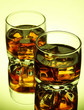Brandy glasses with ice on green background