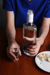 Drunk man drinks vodka at table close-up