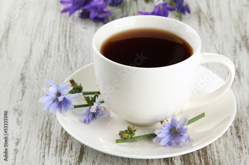 Photo: Cup of tea with chicory, on wooden background Cup of tea with chicory, on wooden background