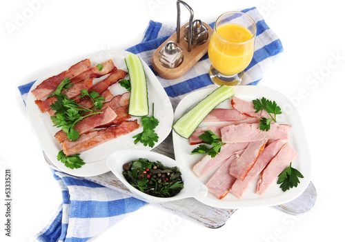 Photo: Bacon on plates on napkin on board isolated on white Bacon on plates on napkin on board isolated on white