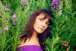 Beautiful young woman posing against a background of green grass