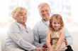 Grandparents laughing with granddaughter