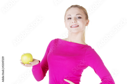 Photo: Young woman holding green fresh apple in hand. Young woman holding green fresh apple in hand.