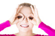 Young woman looking through imaginary binocular