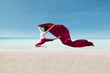 Beautiful dancer with red flag at beach