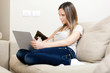 Woman using a laptop while relaxing on the sofa