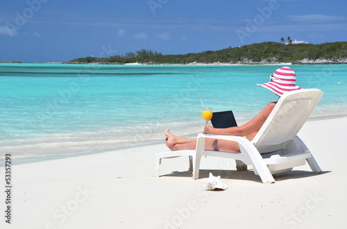 Photo: Girl with a laptop on the tropical beach. Exuma, Bahamas Girl with a laptop on the tropical beach. Exuma, Bahamas