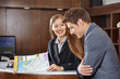 Photo: Empfangsdame im Hotel hilft Gast mit Stadtplan Empfangsdame im Hotel hilft Gast mit Stadtplan