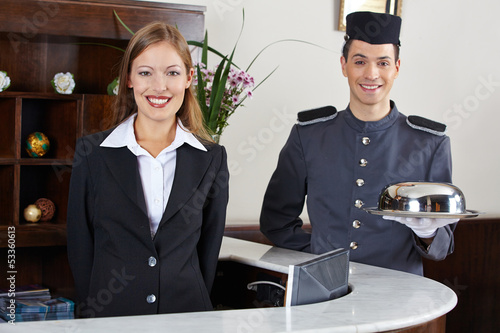 Photo: Hotelpage und Empfangsdame an Rezeption Hotelpage und Empfangsdame an Rezeption