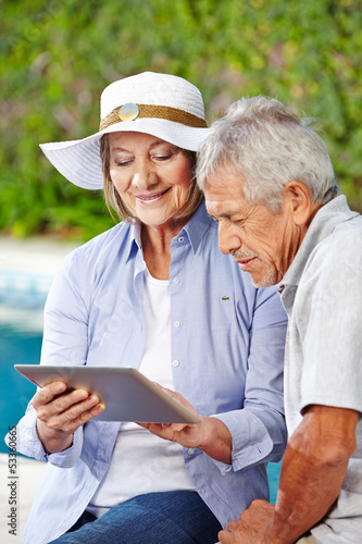 Photo: Senioren schauen auf Tablet PC im Urlaub Senioren schauen auf Tablet PC im Urlaub