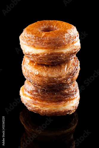Photo: Croissant and doughnut mixture pile isolated on black Croissant and doughnut mixture pile isolated on black