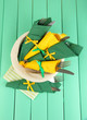 Forks and knives wrapped in green and yellow paper napkins,