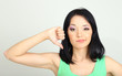 Young woman showing thumbs down on grey background