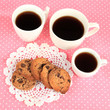 Photo: Cups of coffee with cookies on pink napkin Cups of coffee with cookies on pink napkin