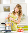 pregnant woman using a juicer, standing in the kitchen