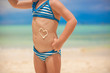 Close-up heart painted by sun cream on little girl's belly