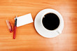 coffee cup, piece of paper and pen on the wooden table