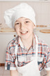 portrait of a happy little chef in a cap and apron in the