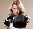 Portrait of blonde sportish woman in boxing gloves