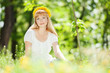 Photo: Cute woman rest in the park with dandelions Cute woman rest in the park with dandelions