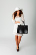 frau mit mit weißem kleid, tasche und hut