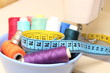 Colorful spools of thread, tape measure and thimble