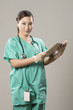 Beautiful Chinese doctor reading a digital tablet & wearing scru