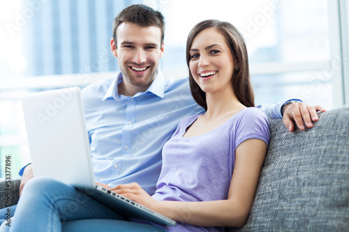 Photo: Couple on sofa with laptop Couple on sofa with laptop