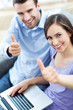 Photo: Couple with laptop showing thumbs up Couple with laptop showing thumbs up