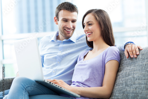 Photo: Couple on sofa with laptop Couple on sofa with laptop