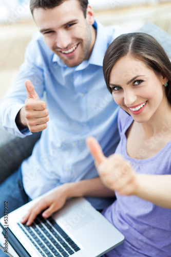 Photo: Couple with laptop showing thumbs up Couple with laptop showing thumbs up