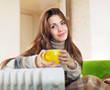 Foto: woman near oil heater at home woman near oil heater at home