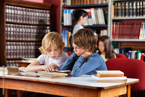 Photo: Schoolboys Reading Book Together In Library Schoolboys Reading Book Together In Library