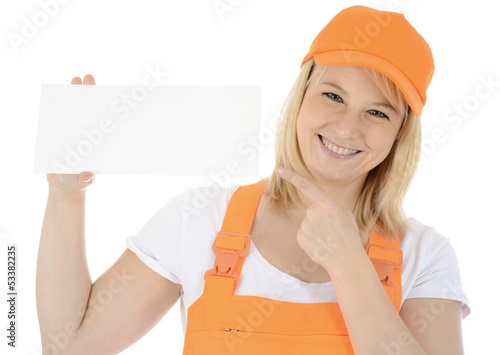 Photo: Freundliche Bauarbeiterin zeigt auf leeres Schild Freundliche Bauarbeiterin zeigt auf leeres Schild