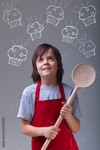Photo: Young chef with apron and large wooden spoon Young chef with apron and large wooden spoon
