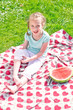 Photo: Little girl sitting on a blanket in the park Little girl sitting on a blanket in the park