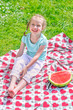 Photo: Little girl sitting on a blanket in the park Little girl sitting on a blanket in the park