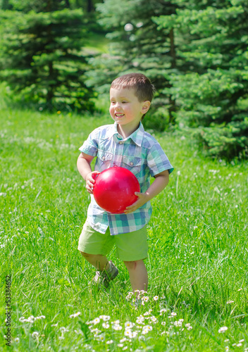 Photo: Little boy playing with ball in the park Little boy playing with ball in the park