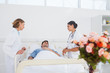 Lying patient in his bed looking to his doctors