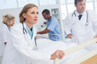 Doctors about to walk with patient bed
