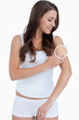 Standing woman rubbing her skin with close up of her wrinkles
