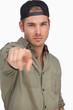 Man wearing baseball hat backwards and pointing
