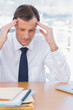 Anxious businessman holding his head